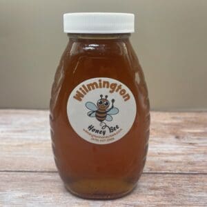 A jar of honey sitting on top of a wooden table.